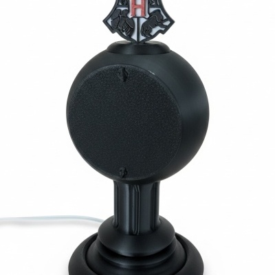 Coluna de som preta com escudo de Hogwarts no topo