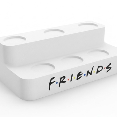 Suporte branco de plástico com texto FRIENDS e cavidades circulares.