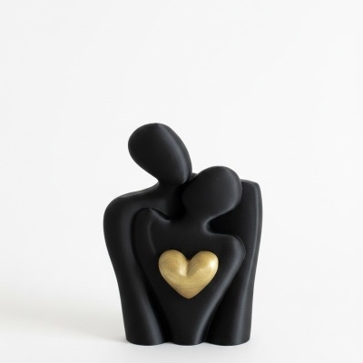 Escultura decorativa preto e dourado com figuras abstratas abraçadas