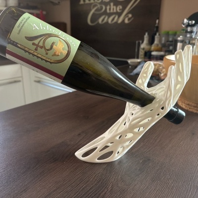 Garrafas de vidro verde com rótulo Abbatissa em suporte branco na cozinha