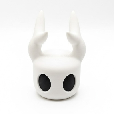 Figura decorativa branca com orelhas pontiagudas e olhos pretos ovais