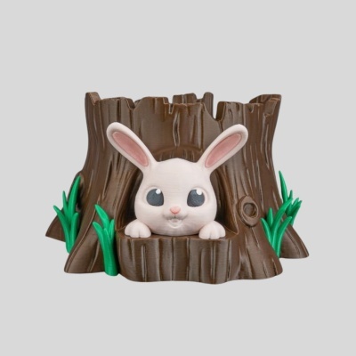 Escultura decorativa de coelho branco a sair de árvore castanho escura com folhas verdes