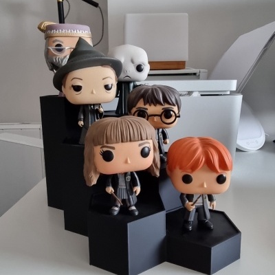 Figuras Funko Pop Harry Potter em pedestal preto sobre mesa branca