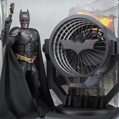 Figura do Batman ao lado de projetor com símbolo do morcego