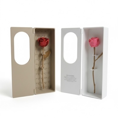 Duas caixas retangulares abertas com rosas artificiais, uma bege e outra branca.