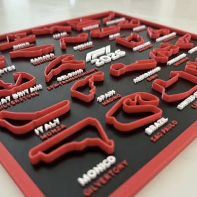 Quadro com réplicas vermelhas em relevo de circuitos de corridas sobre fundo preto com texto F1 2026