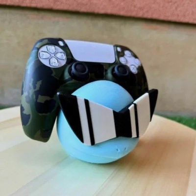 Objeto azul esférico com óculos pretos e brancos e comando de videojogo camuflado preto