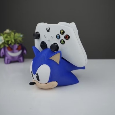 Suporte comando Xbox em figura Sonic azul sobre mesa branca