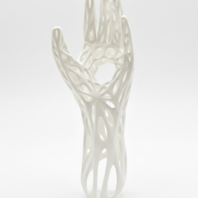Escultura branca em forma de mão com design aberto e estrutura de rede.