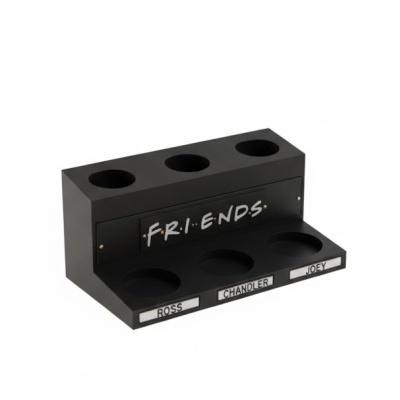 Suporte preto para copos com texto FRIENDS e etiquetas com nomes Ross, Chandler e Joey