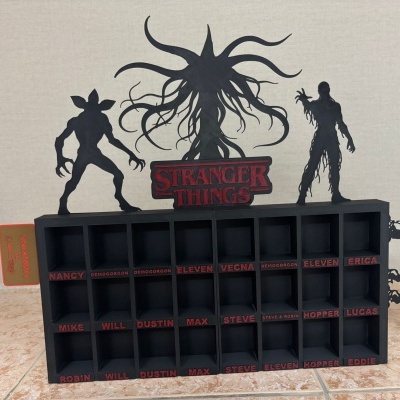 Organizador preto com divisórias e silhuetas de monstros de Stranger Things e logótipo no topo