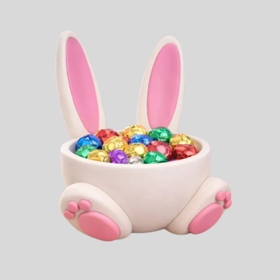 Recipiente de coelho branco com ovos de chocolate coloridos