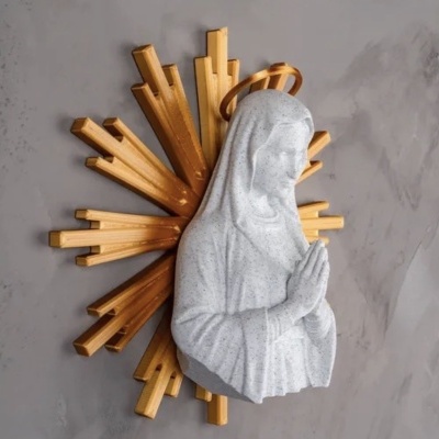 Escultura decorativa de Nossa Senhora com auréola e raios dourados na parede cinzenta