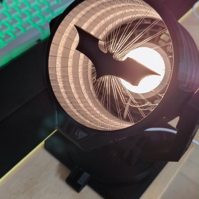 Luminária bat-sinal preto com morcego no centro e teclado retroiluminado verde ao fundo
