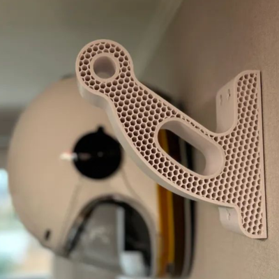 Suporte de parede plástico bege com textura colmeia e capacete branco pendurado