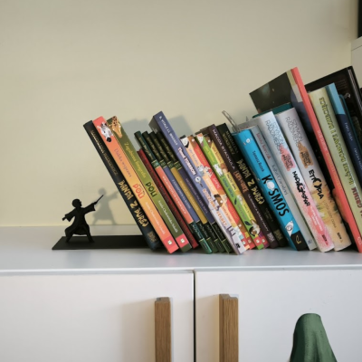 Estante branca com livros coloridos e suporte metálico de mago em preto