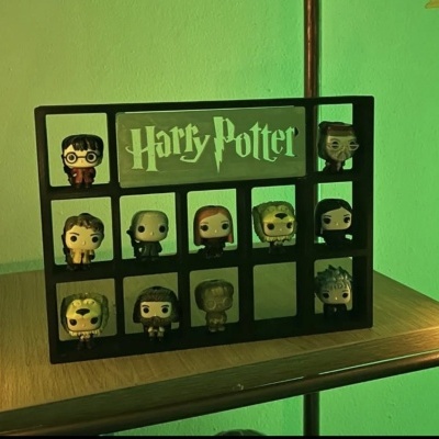 Expositor de figuras Funko Pop Harry Potter numa prateleira de madeira com parede verde ao fundo