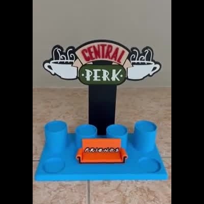 Suporte azul com inscrição Central Perk e sofá laranja com a palavra FRIENDS