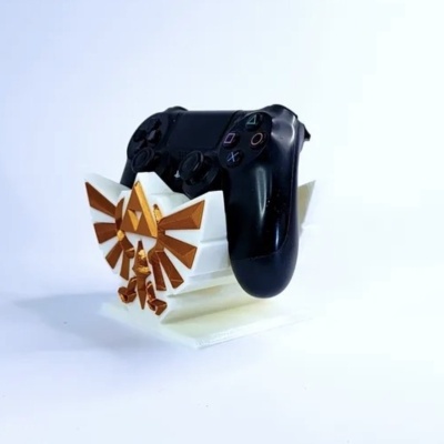 Suporte branco e dourado com comando preto de videojogos sobre fundo branco.