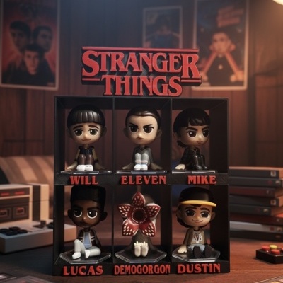Figuras colecionáveis da série Stranger Things em caixa preta com cinco personagens humanos e um Demogorgon.