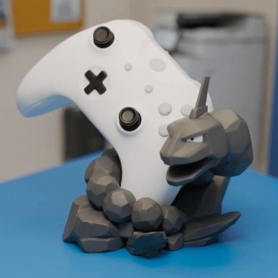 Suporte de comando branco com figura de pedra cinzenta escura em cima de mesa azul