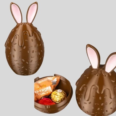 Caixa em forma de ovo de chocolate com orelhas de coelho e chocolates no interior