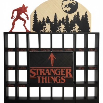 Estrutura organizadora preta com tema Stranger Things com figuras vermelhas e desenho de bicicleta e árvores em madeira