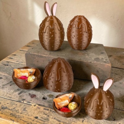 Ovos de chocolate com textura e decoração de coelho em superfície de madeira