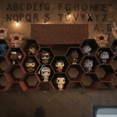 Estante de madeira com mini figuras Funko Pop de Stranger Things e luzes decorativas
