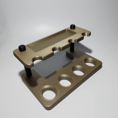 Suporte ou organizador de plástico dourado com buracos circulares e recortes