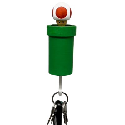 Suporte para chaves verde com cogumelo branco e vermelho e várias chaves penduradas.