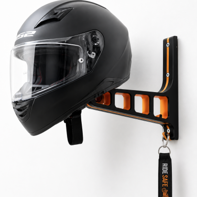 Capacete integral preto com viseira transparente num suporte de parede preto e laranja com etiqueta RIDE SAFE
