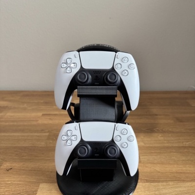 Suporte preto com dois comandos PlayStation 5 brancos