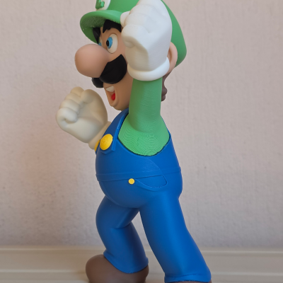 Figura de brinquedo Luigi de Super Mario com roupa azul e verde em fundo branco.
