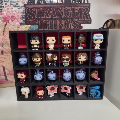 Expositor preto com figuras Stranger Things e texto no topo