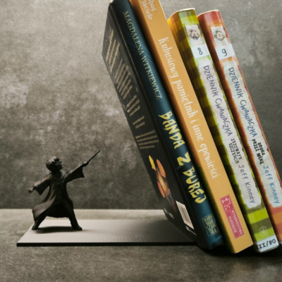Suporte de livros em metal com figura e livros coloridos apoiados.