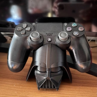 Comando de consola preto com suporte de capacete Darth Vader sobre mesa