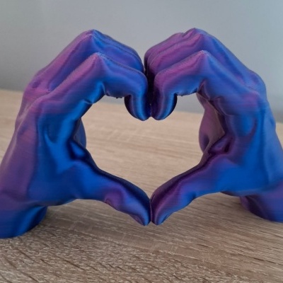 Escultura azul de mãos formando um coração
