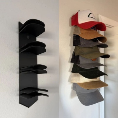 Suporte de parede preto para chapéus ao lado de vários bonés pendurados na parede