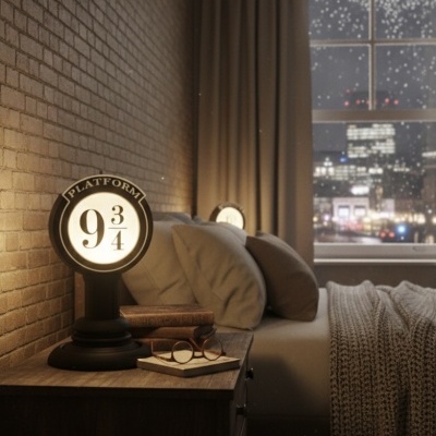 Candeeiro de mesa preto com luz branca e texto PLATFORM 9 3/4 na mesa de cabeceira ao lado da cama