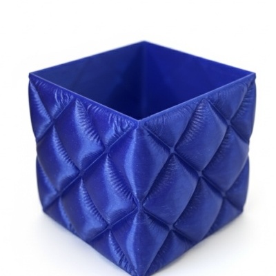 Caixa azul quadrada com padrão acolchoado.