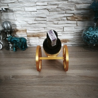 Suporte para garrafa dourado em forma de carrinho com garrafa preta
