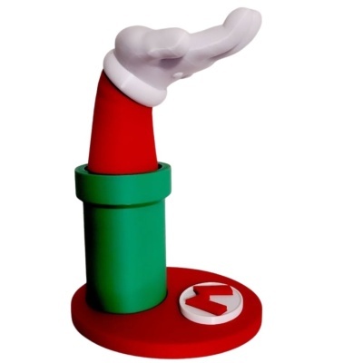 Objeto decorativo com braço branco de luva e manga vermelha saindo de um cano verde numa base vermelha