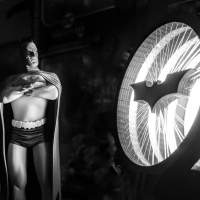 Figura do Batman com luz circular do símbolo do morcego ao lado