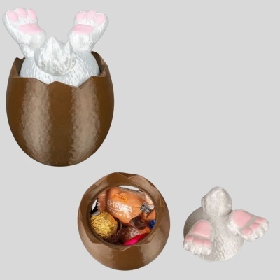 Ovos de chocolate castanho com tampa de coelho branco e doces dentro