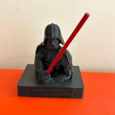 Figurine Darth Vader preta com espada vermelha e base com texto