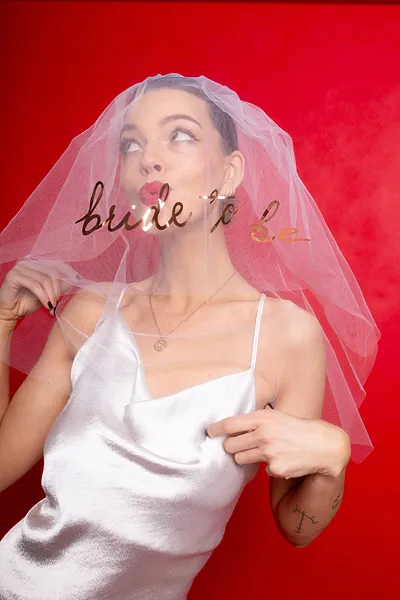 Véu de noiva branco com texto dourado bride to be sobre vestido branco