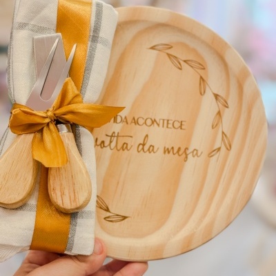 Prato de madeira com texto e guardanapo amarrado com fita e utensílios