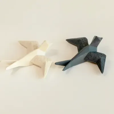 Figuras decorativas de aves em cores bege claro e cinza escuro