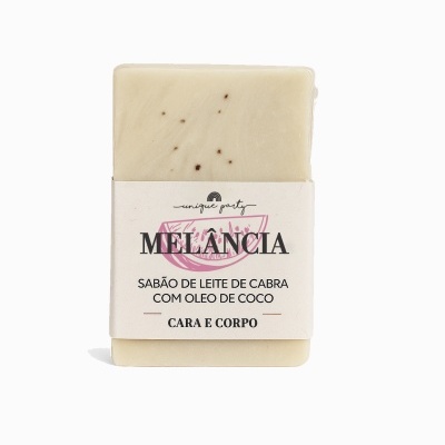 Sabonete sólido creme com pintas escuras e embalagem branca com texto em português